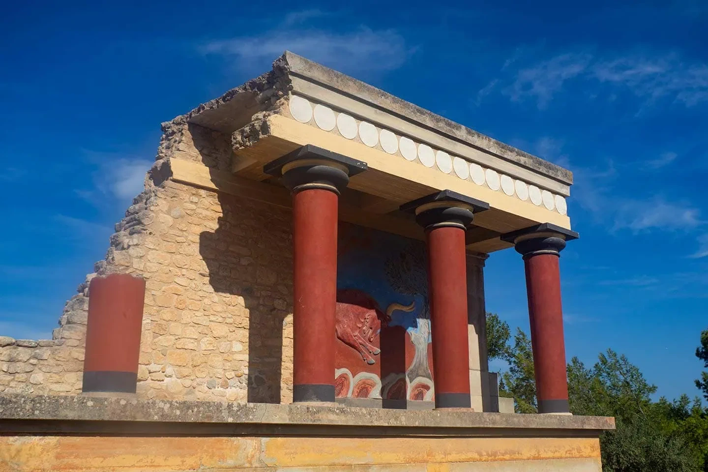 Red stone columns and ancient Minoan ruins at the Palace of Knossos in Crete
